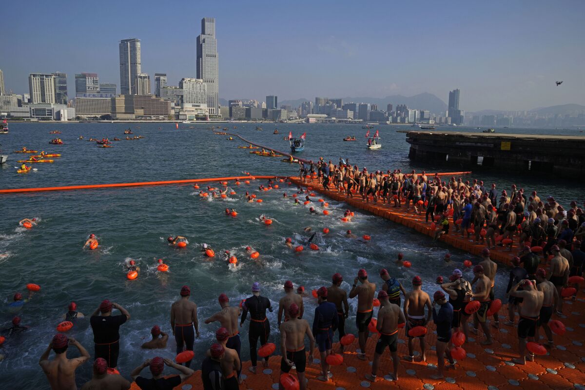 Competitors swim during a harbor race at the Victoria Harbor in Hong Kong, Sunday, Dec. 12, 2021. Hundreds of people took part in traditional swim across iconic Victoria Harbor after two years of suspension. (AP Photo/Kin Cheung)