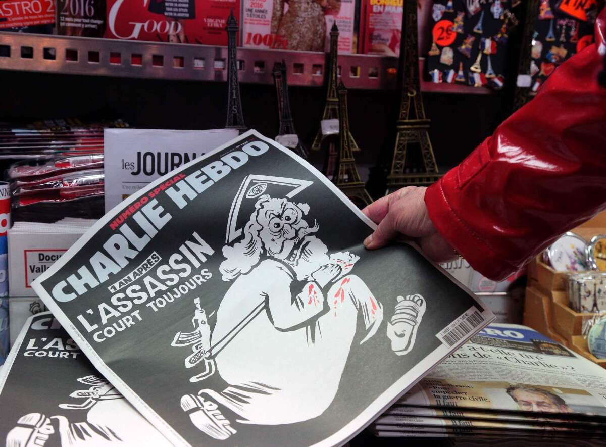 A woman looks at the special commemorative edition of French satirical newspaper Charlie Hebdo at a newsstand in Paris, on Jan. 6, 2015, to mark the one-year anniversary of the jihadist attack that claimed the lives of 12 people, including three cartoonists.