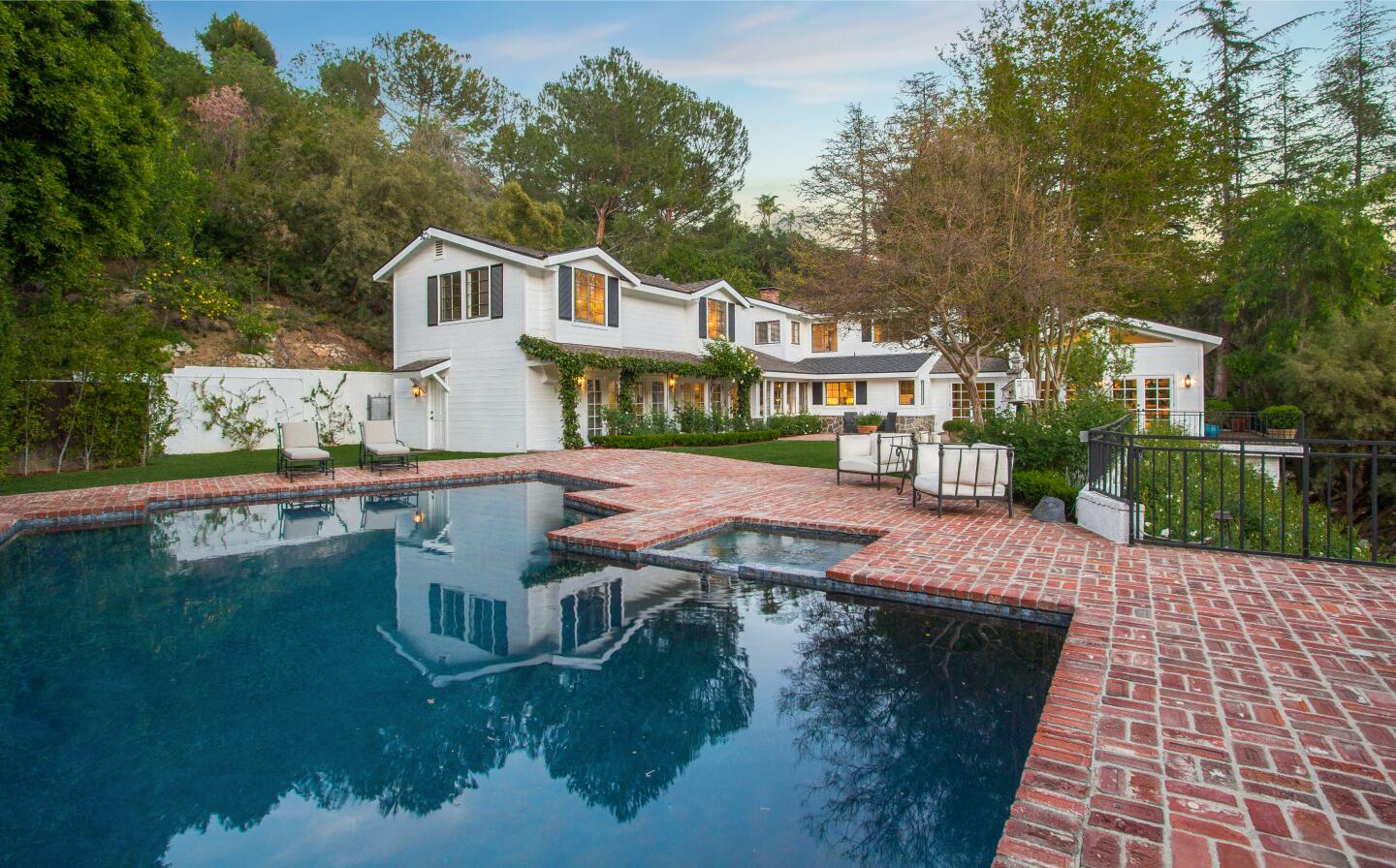 The 1.5-acre spread includes a swimming pool, tennis court and L-shaped home built in the 1970s.