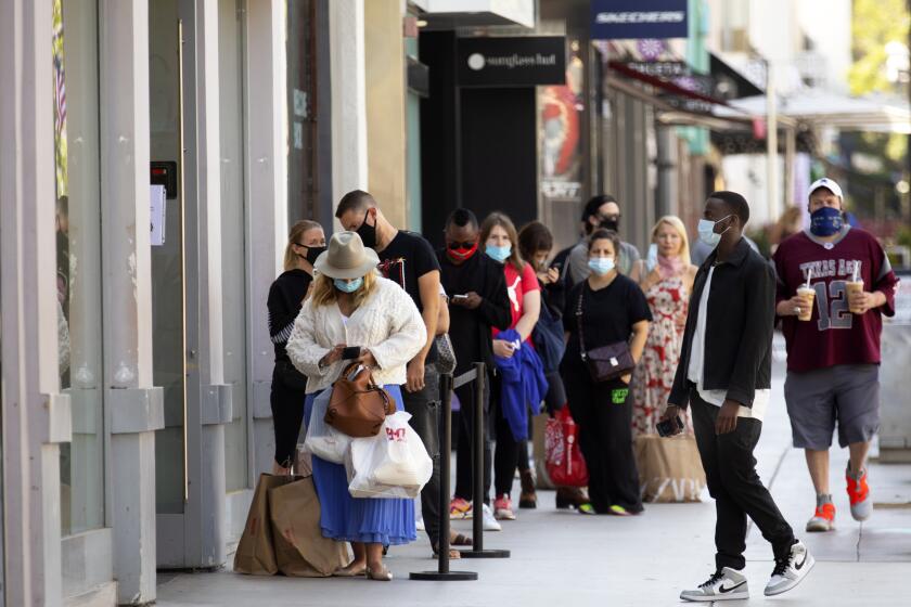 SANTA MONICA, CA - JULY 01: Masked people line up to go inside Zara on the 3rd Street Promenade on Wednesday, July 1, 2020 in Santa Monica, CA. (Francine Orr / Los Angeles Times)
