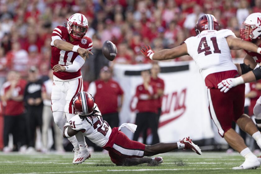 Nebraska quarterback Casey Thompson (11) passes the ball while still in the pocket as Indiana's Indiana defensive back Noah Pierre (21) dives in for the tackle during the first half of an NCAA college football game Saturday, Oct. 1, 2022, in Lincoln, Neb. Thompson was called for intentional grounding on the play. (AP Photo/Rebecca S. Gratz)