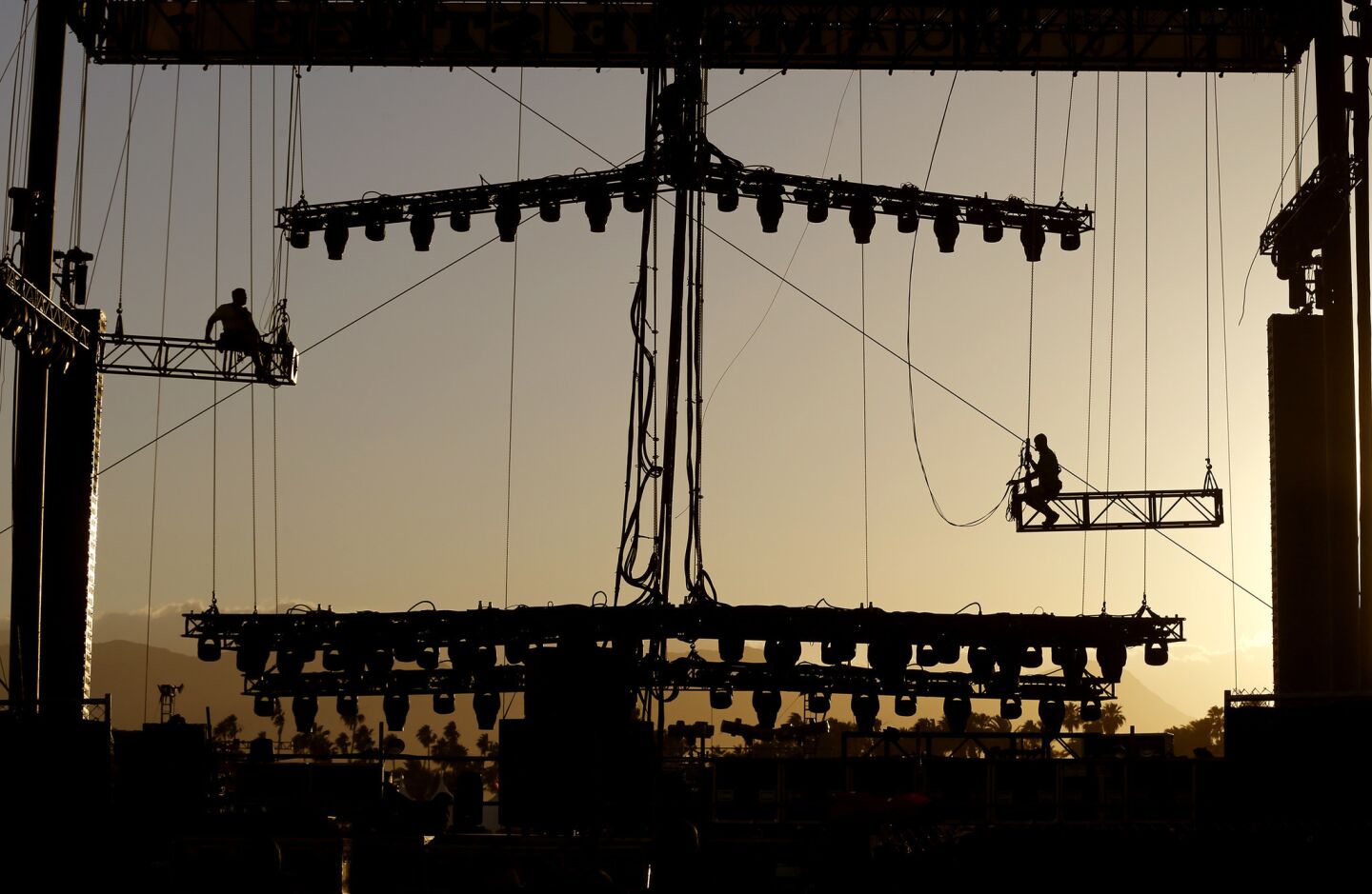 Crew members put up lighting at sunset on the Mane Stage on Thursday at the 10th anniversary of Stagecoach Country Music Festival at the Empire Polo Club in Indio.