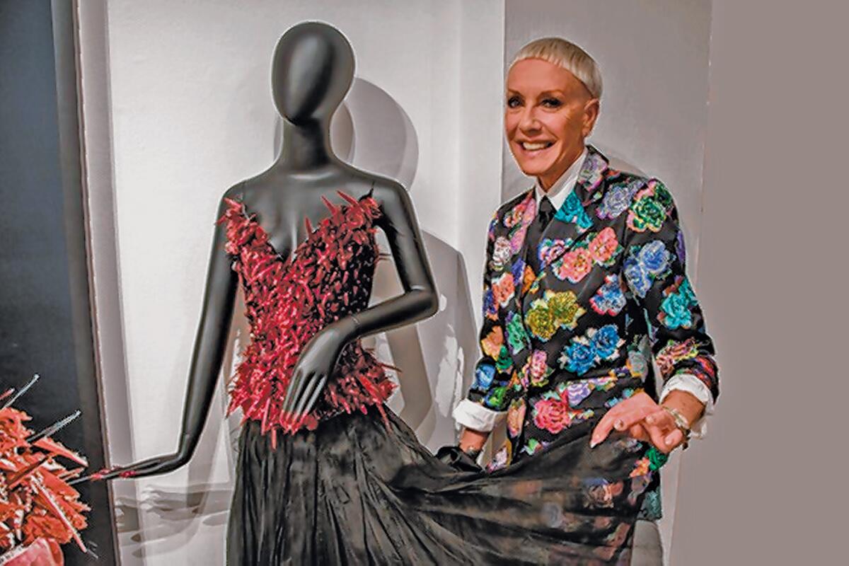 Jan Arnold with a Ruby Corset made of hundreds of nail tips by designers David and Phillipe Blond. She is the co-producer of “Tiny Canvases: The Art of Nails” exhibit, on display through Feb. 9, 2020 at Oceanside Museum of Art.