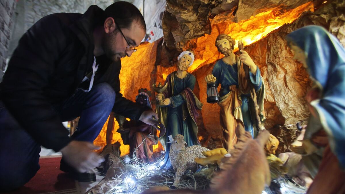 A Syrian man decorates the Saint Mary Church of the Holy Belt with a Christmas Nativity scene in the bombed-out city of Homs on Sunday.