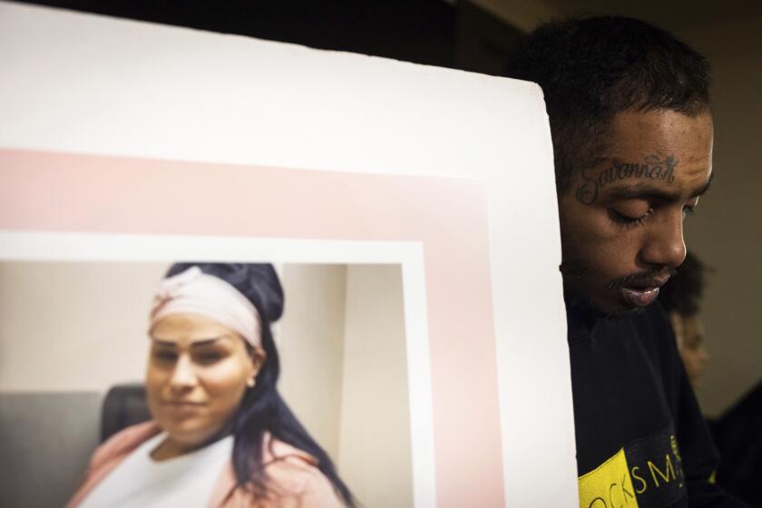 FILE - Courtuni Mason stands next to a poster of his partner Savannah Williams during a press conference at the State Capitol on Dec. 7, 2023, in St. Paul, Minn. (Ben Hovland/Minnesota Public Radio via AP, file)