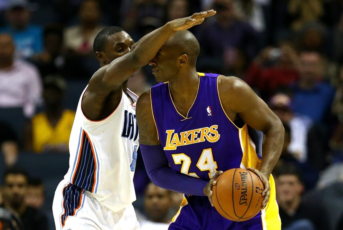 Kobe Bryant gets a close look at the forearm of Charlotte's Ben Gordon during the Lakers' 88-85 victory Saturday at Time Warner Cable Arena.