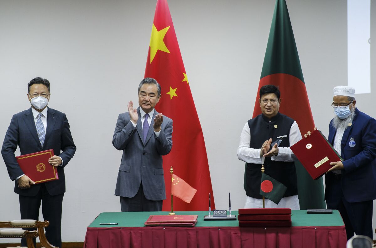 Chinese Foreign Minister Wang Yi, center left, and his Bangladeshi counterpart A.K. Abdul Momen applaud as both countries sign agreements in Dhaka, Bangladesh, Sunday, Aug.7, 2022. (AP Photo/Mahmud Hossain Opu)