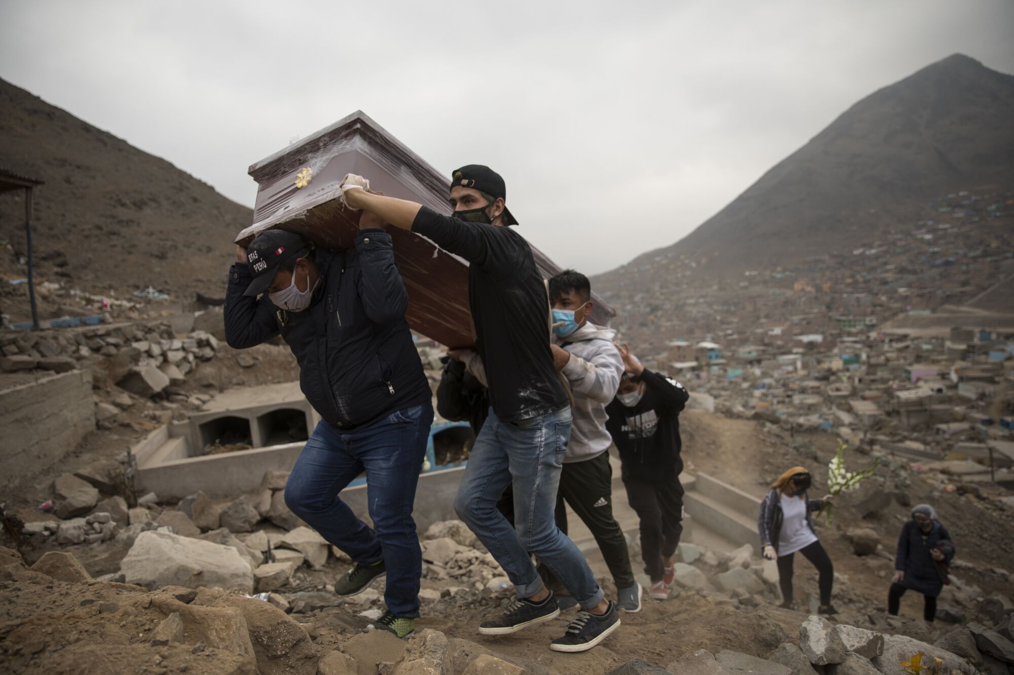 Relatives of Ronald Palomo, carry his coffin for burial at the cemetery  in Comas on the outskirts of Lima.