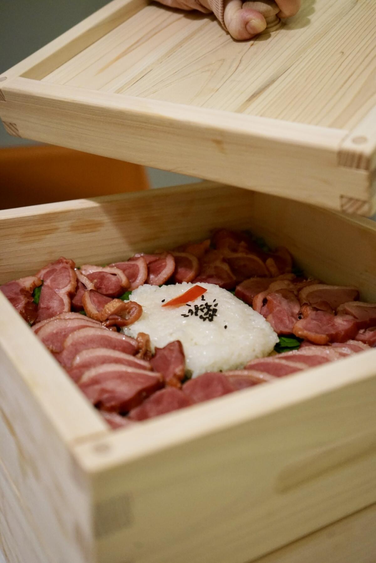 The smoky duck in the Korean Koreatown cuisine is served in an Hinoki wooden box.