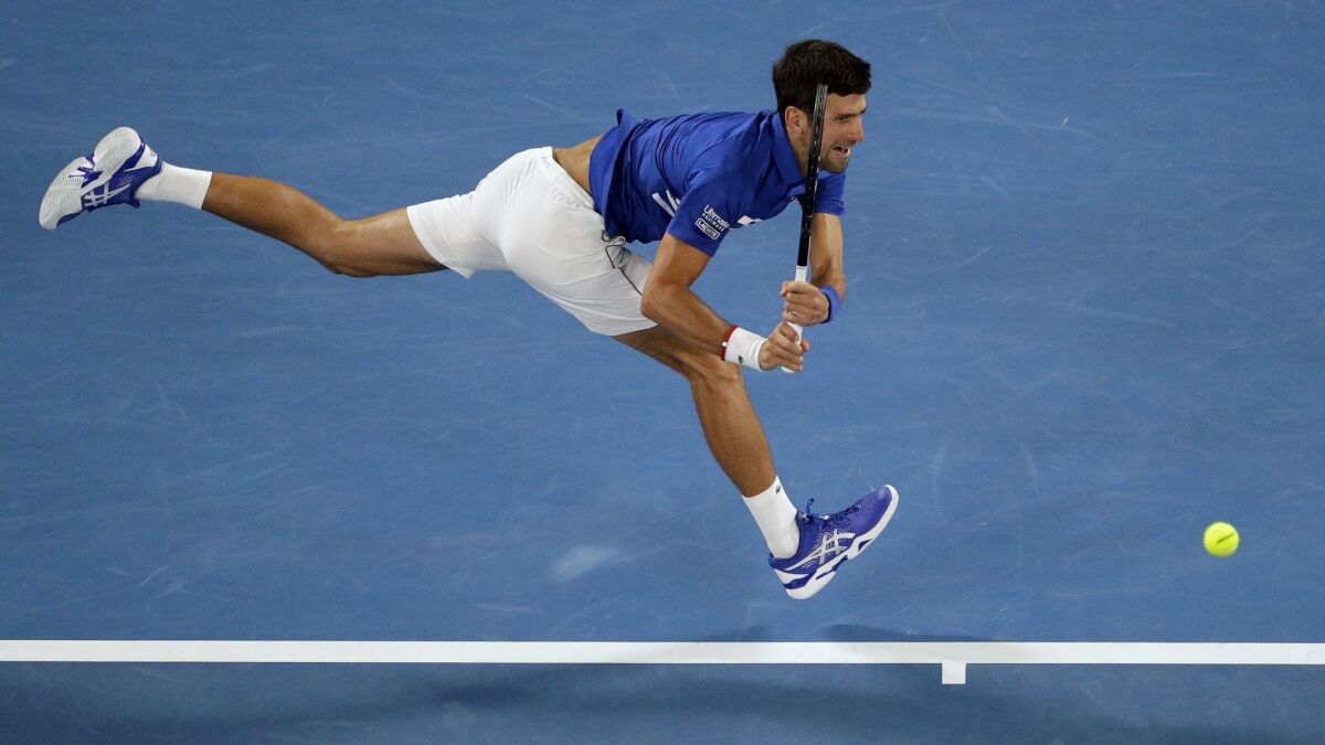 Novak Djokovic makes a backhand return to Rafael Nadal during the men's singles final at the Australian Open.