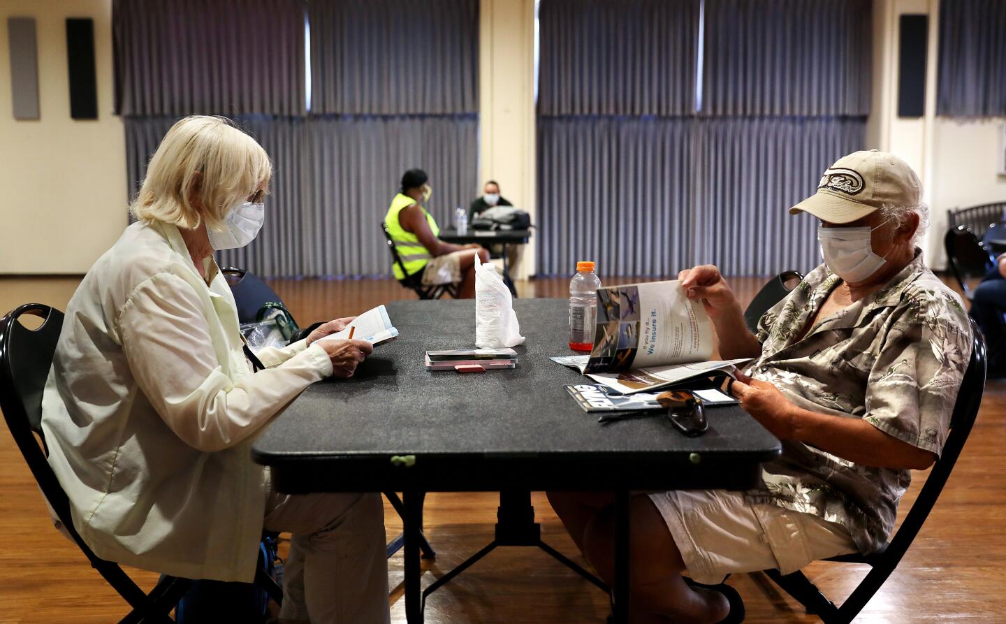 Rita Zeid, 79, left, works on puzzles and her husband, Mike, 84, reads magazines while cooling off Sunday.