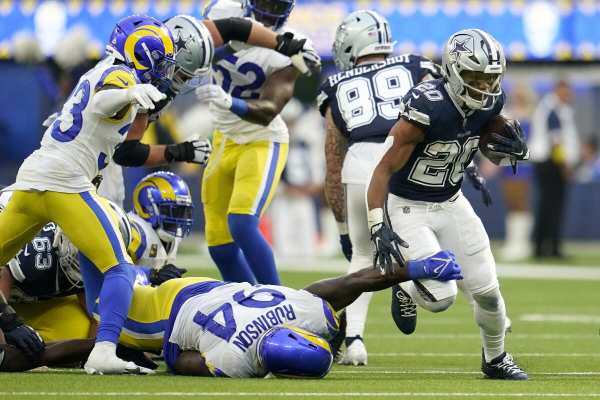 Dallas Cowboys running back Tony Pollard races past Rams defensive tackle A'Shawn Robinson.