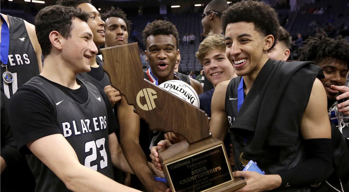Sierra Canyon's Jacob Miller, left, and Scotty Pippen Jr. right, hold the championship trophy as the Trailblazers celebrate their Open Division state title on March 9.