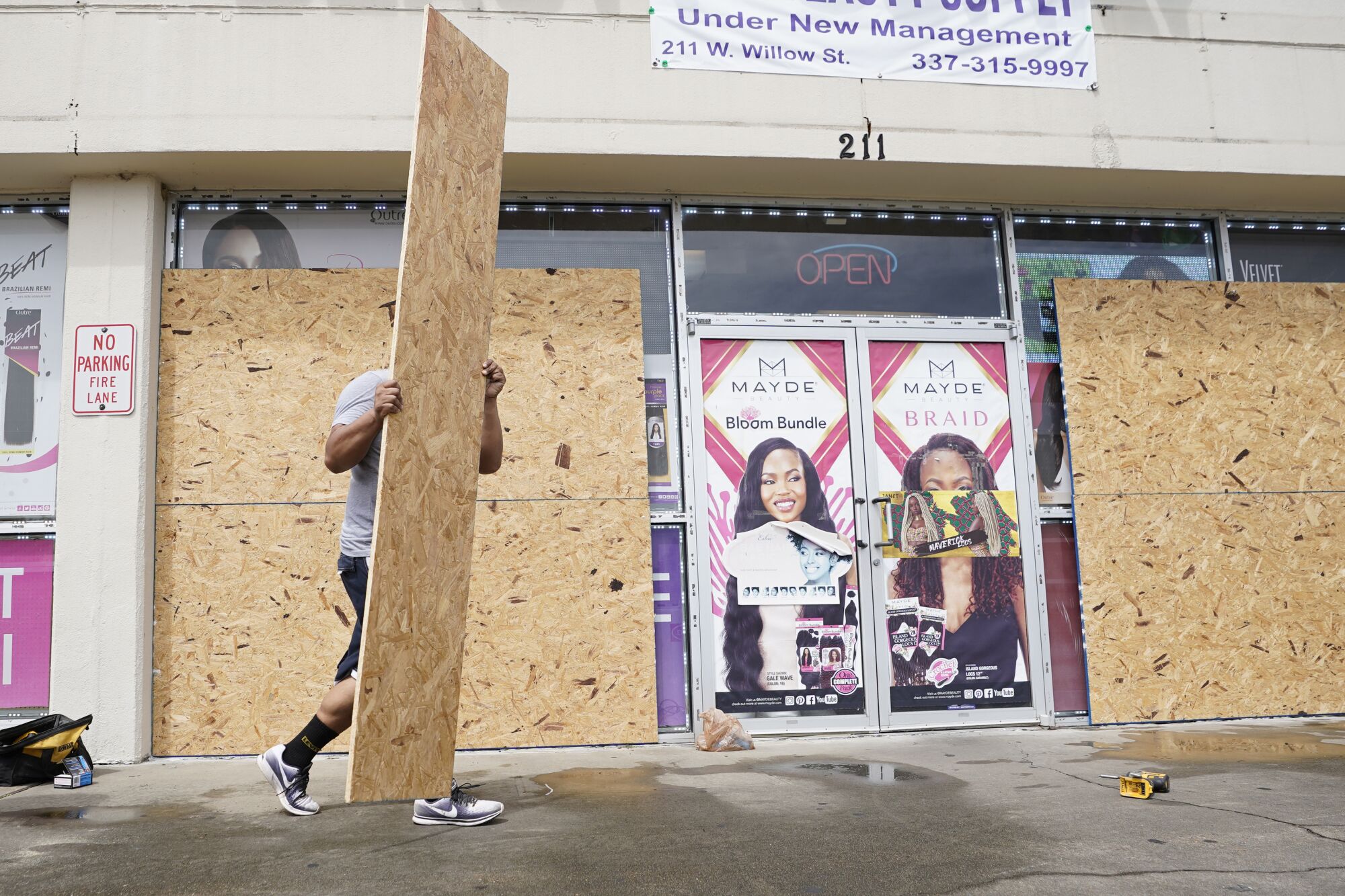 A person boards up the windows of a business.