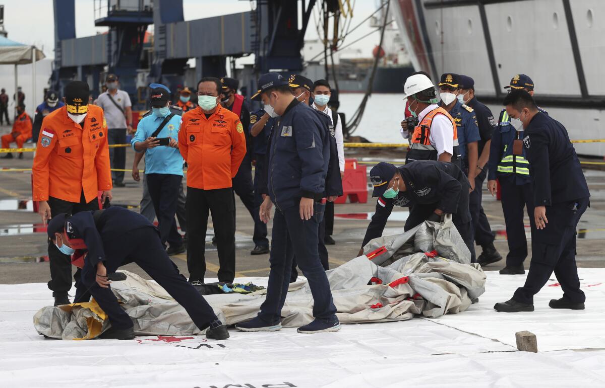 Rescuers inspect debris found in the waters near where a passenger jet has lost contact with air traffic controllers 