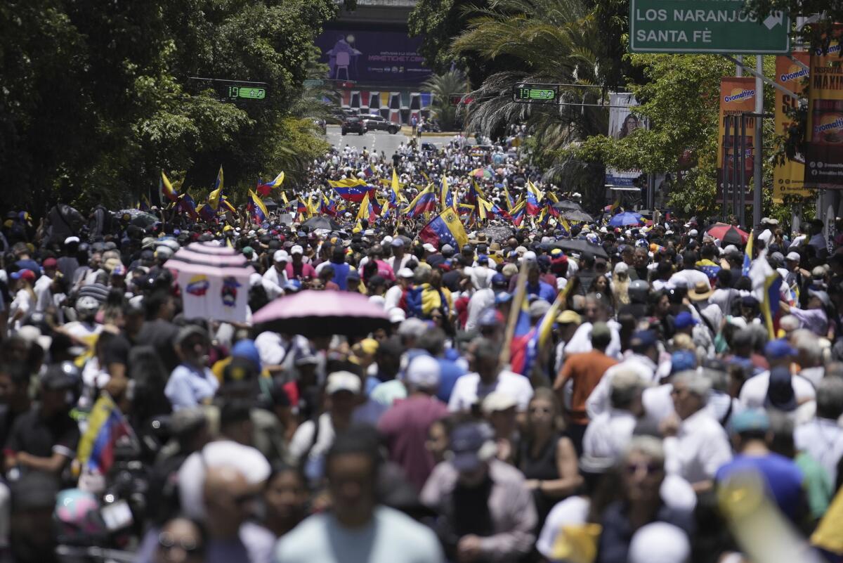 La líder opositora María Corina Machado aplaude junto a sus partidarios durante 