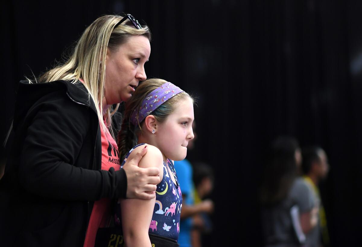 Samantha Goodman, 11, left, prepares to make a lift as her coach Anna Martin gives encouragement at the USA Weightlifting National Youth Championships at the Anaheim Convention Center.. (Wally Skalij / Los Angeles Times)