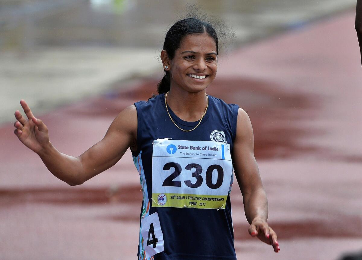 Indian athlete Dutee Chand waves to the crowd after completing a race in India in 2013.