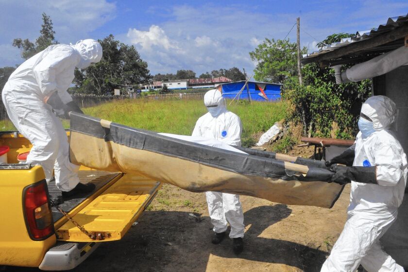 Health workers carry the body of a suspected Ebola victim from his home on the outskirts of Monrovia, Liberia.