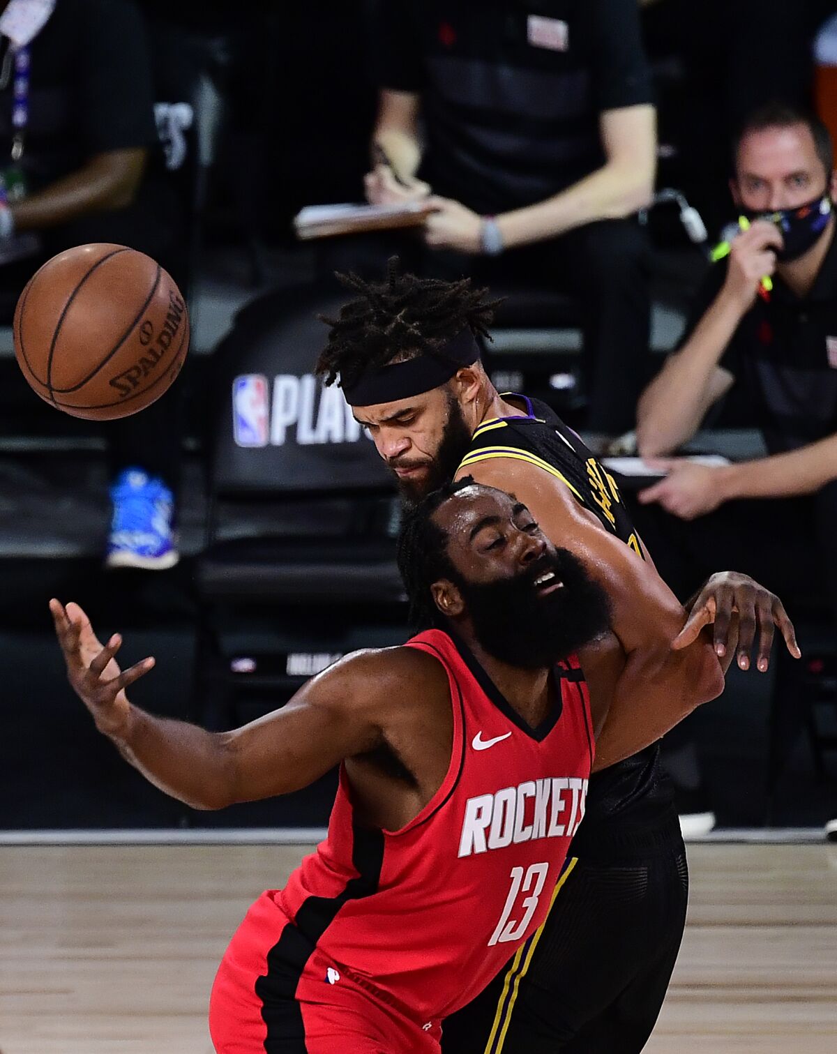 James Harden of the Houston Rockets is defended by JaVale McGee of the Lakers.