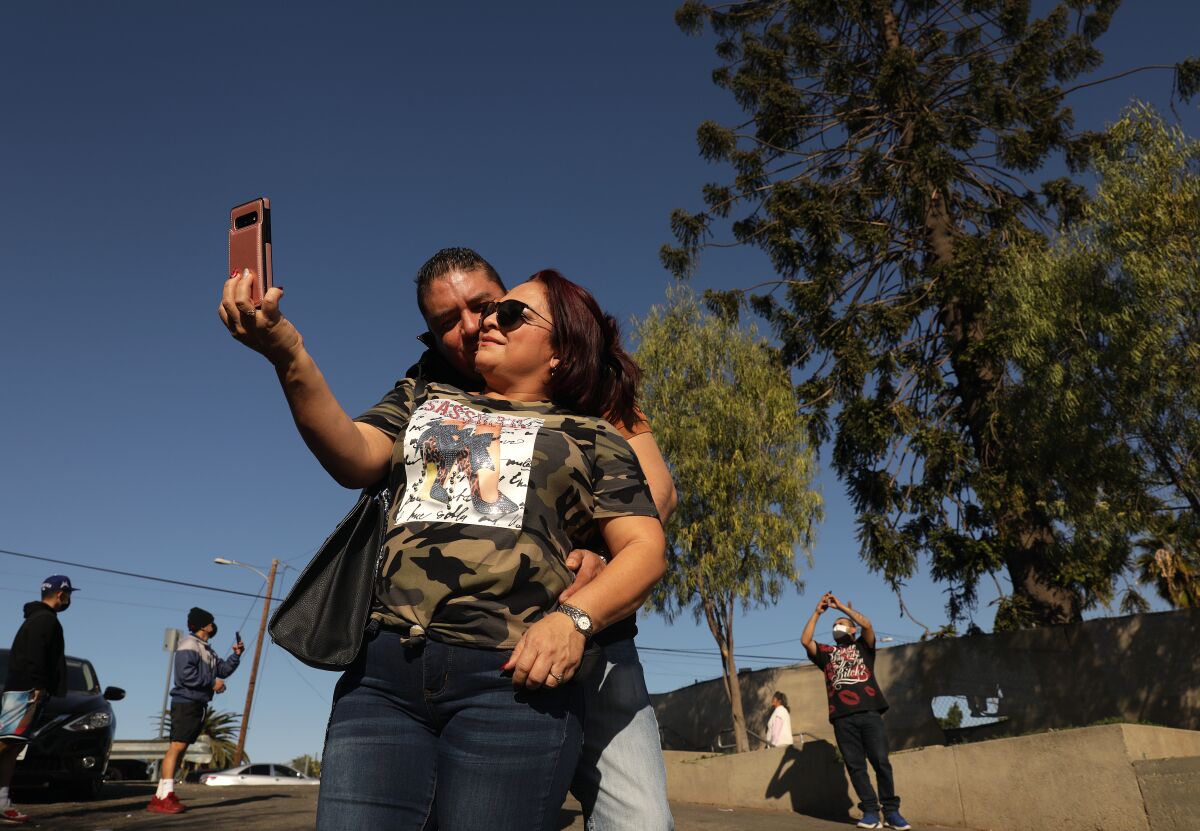 Tourists take a selfie in front of the world-famous pine tree in East Los Angeles known as "El Pino."