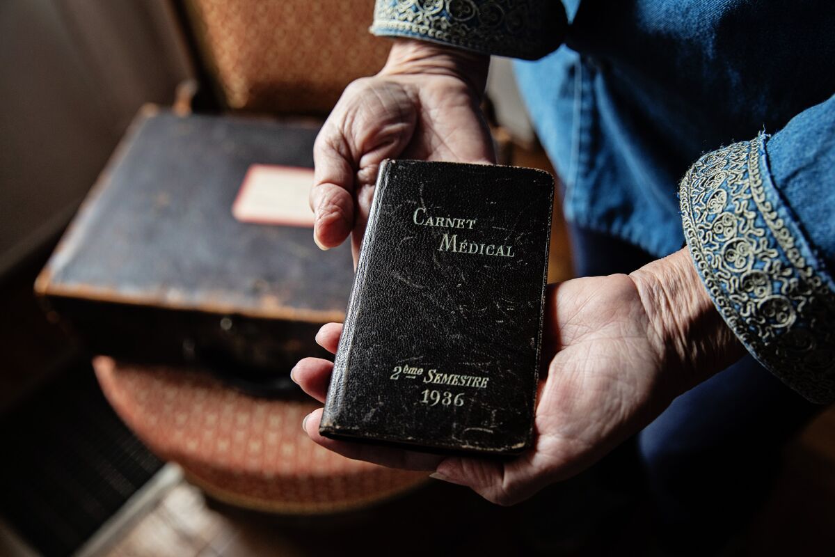 Kitty Morse holds a small medical notebook that her great-grandfather used as a journal.