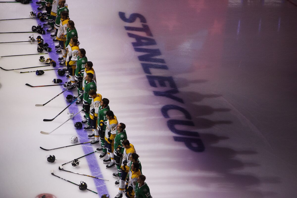 Nashville Predators and the Dallas Stars stand for the national anthem before NHL hockey exhibition game action in Edmonton, Alberta, Thursday, July 30, 2020. (Jason Franson/The Canadian Press via AP)
