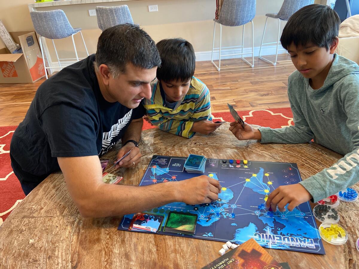 A father and two sons play a board game