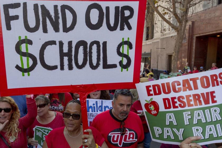 FILE - In this Dec. 15, 2018, file photo, thousands of teachers marched and rallied in downtown Los Angeles. Strike or no strike, after a deal is ultimately reached on a contract for Los Angeles teachers, the school district will still be on a collision course with deficit spending because of pensions and other financial obligations. .(AP Photo/Damian Dovarganes, File)