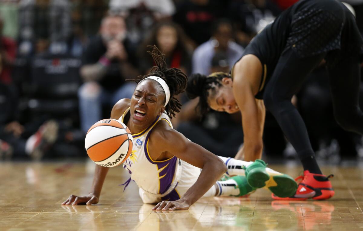Sparks forward Nneka Ogwumike chases after a loose ball in front of Las Vegas Aces forward Candace Parker.