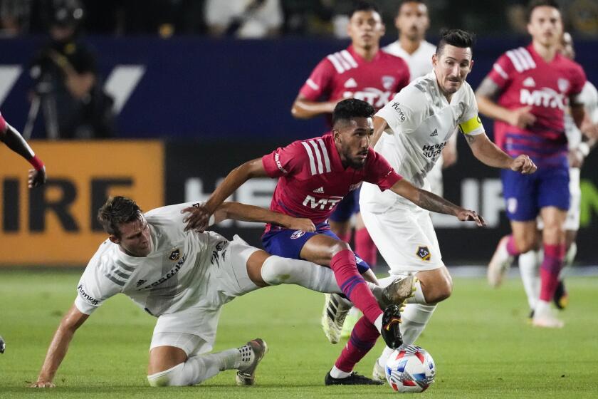 LA Galaxy defender Nick DePuy, left, midfielder Sacha Kljestan, right, and FC Dallas forward Jesus Ferreira, center, battle for the ball during the second half of an MLS soccer game Wednesday, July 7, 2021, in Carson, Calif. (AP Photo/Ashley Landis)