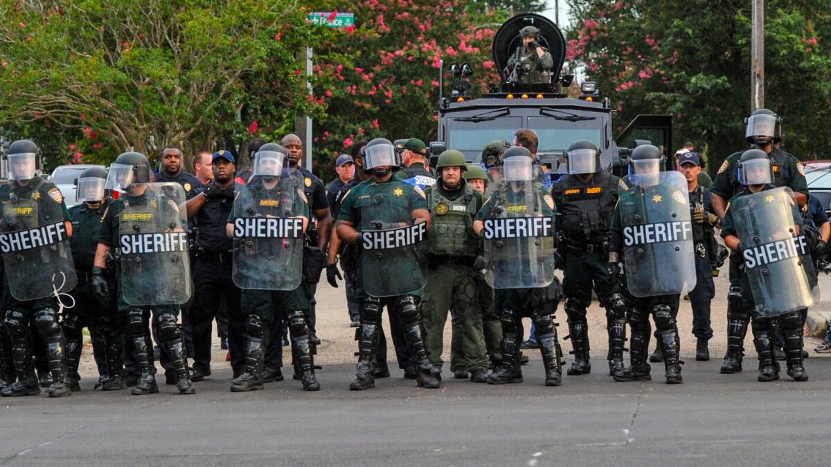 Sheriff's deputies watch protesters gathering against another group of protesters Sunday in Baton Rouge, La.
