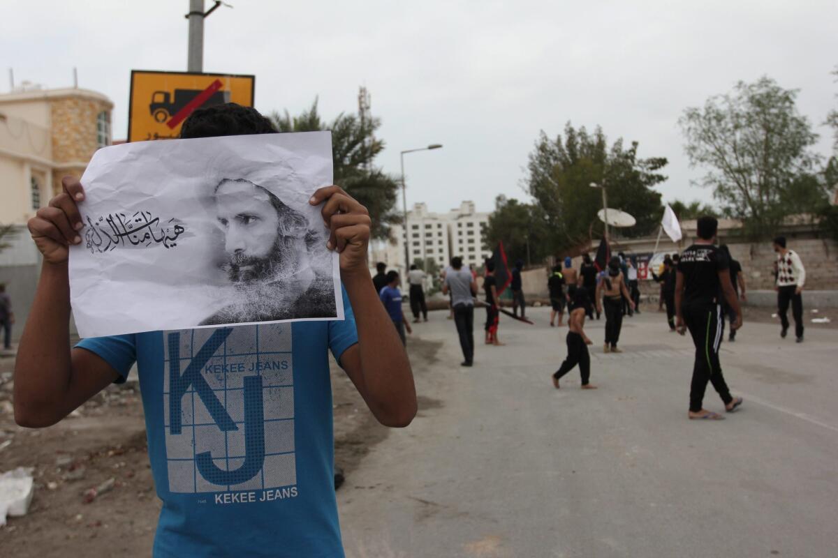 A Bahraini protester holds a picture of Nimr al-Nimr as others clash with security forces after Saudi Arabia executed the prominent Shiite cleric on Jan. 2.