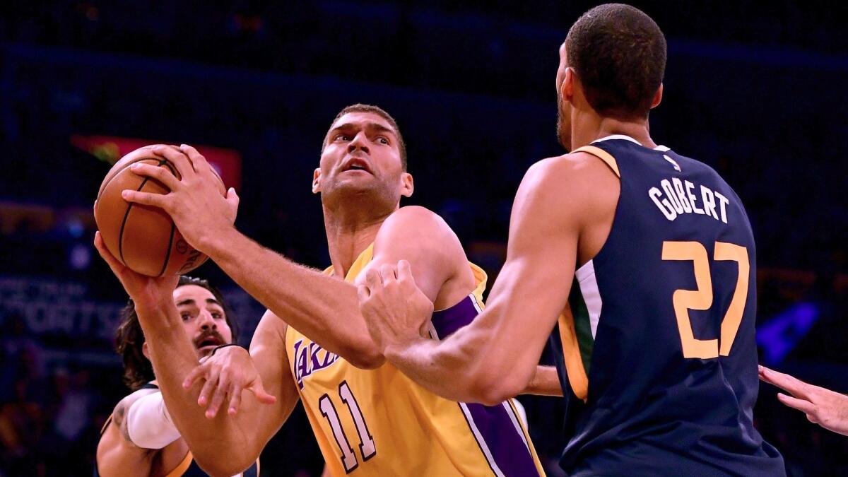 The Lakers' Brook Lopez attempts a shot between Utah's Ricky Rubio, left, and Rudy Gobert on Oct. 10 at Staples Center.