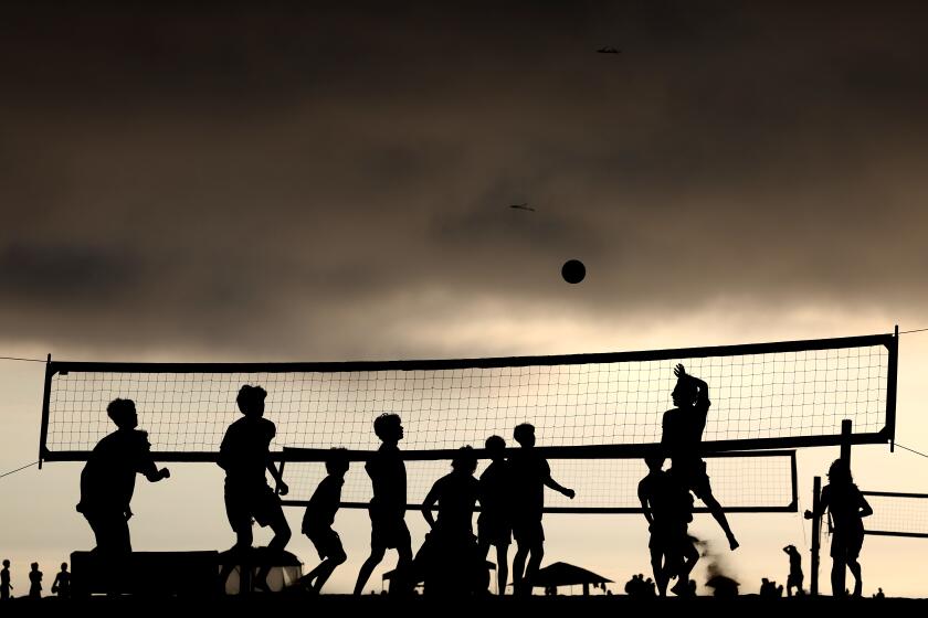 HUNTINGTON BEACH, CALIFORNIA JULY 13, 2024-People play volleyball as the marine layer hangs overhead in Huntington Beach Sunday afternoon. (Wally Skalij/Los Angeles Times)