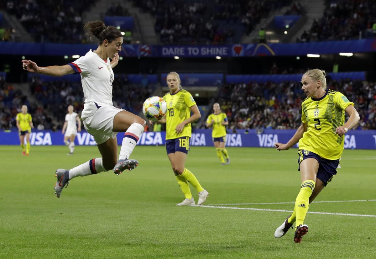 Carli Lloyd, left, leaps to control the ball against Sweden during a Women's World Cup Group game Thursday in Le Havre, France,