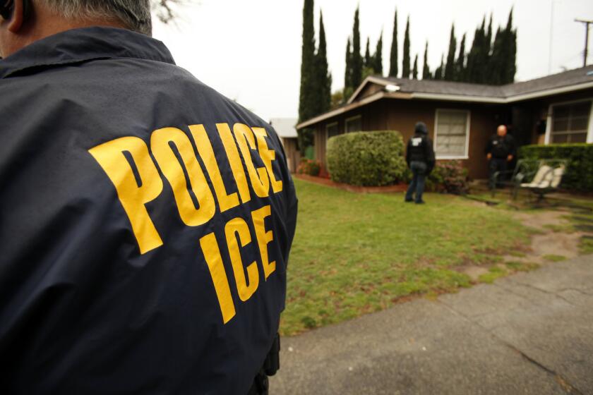 U.S. Immigration and Customs Enforcement agents are shown outside a San Fernando Valley home in 2012. On Friday, the agency announced that it had arrested 50 fugitives suspected in serious crimes abroad.