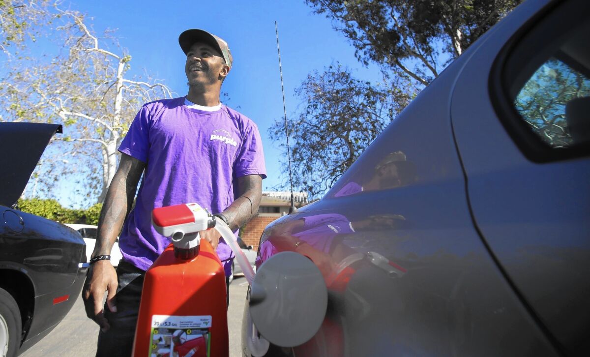 Randy Harvey, a "courier" for on-demand gas app Purple, delivers 10 gallons of gasoline to a San Diego customer last week.