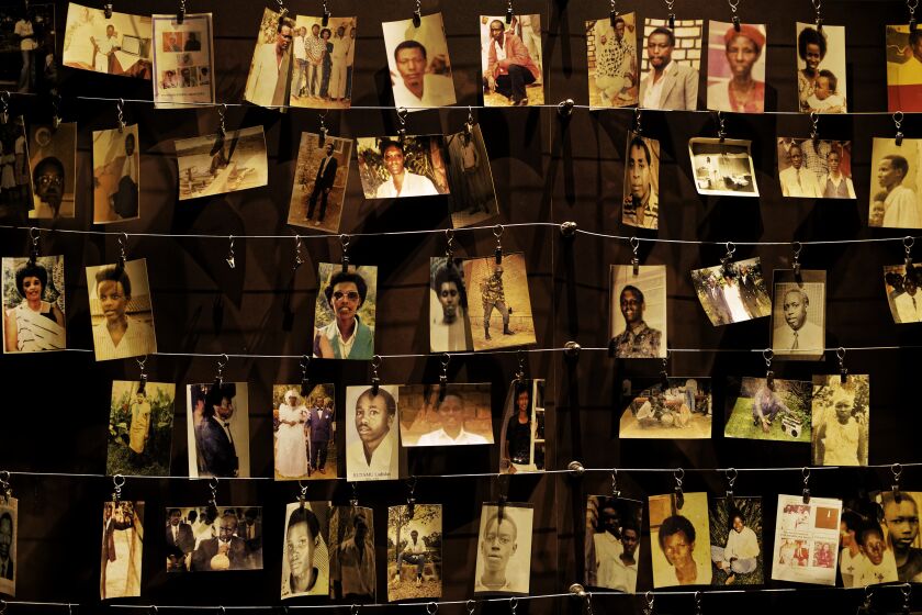 FILE - In this Friday, April 5, 2019 file photo, family photographs of some of those who died hang on display in an exhibition at the Kigali Genocide Memorial centre in the capital Kigali, Rwanda. Felicien Kabuga, one of the most wanted fugitives in Rwanda's 1994 genocide who had a $5 million bounty on his head, has been arrested in Paris, authorities said Saturday, May 16, 2020. (AP Photo/Ben Curtis, File)
