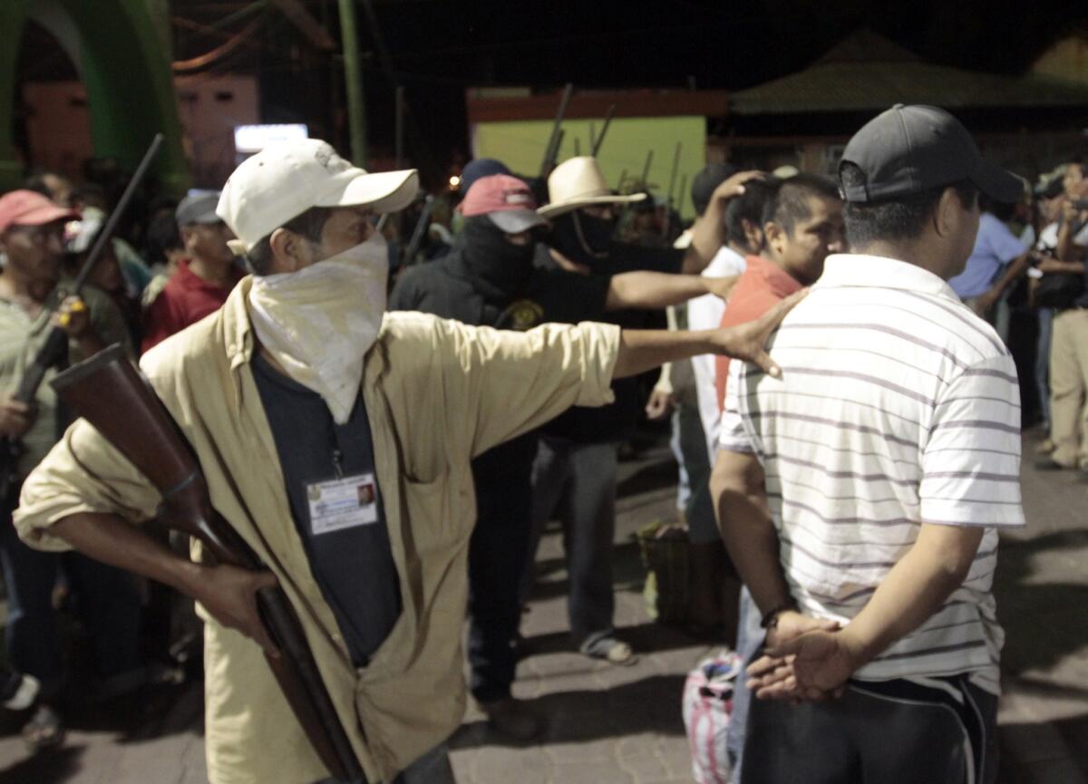 Hooded men guard the detainees at the central square of Ayutla. Hundreds of civilians armed with rifles, pistols and machetes decided to provide security for the communities of Guerrero state, creating a vigilante force, saying gangs were committing robberies, kidnappings and murder.
