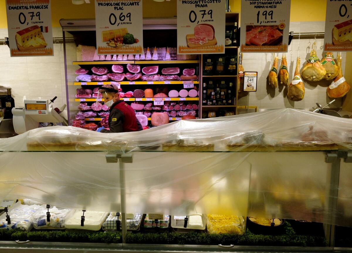 Un empleado de un supermercado protege los alimentos con una lona de plástico antes de proceder a las operaciones de higienización en el cierre, en Roma, el domingo 22 de marzo de 2020.