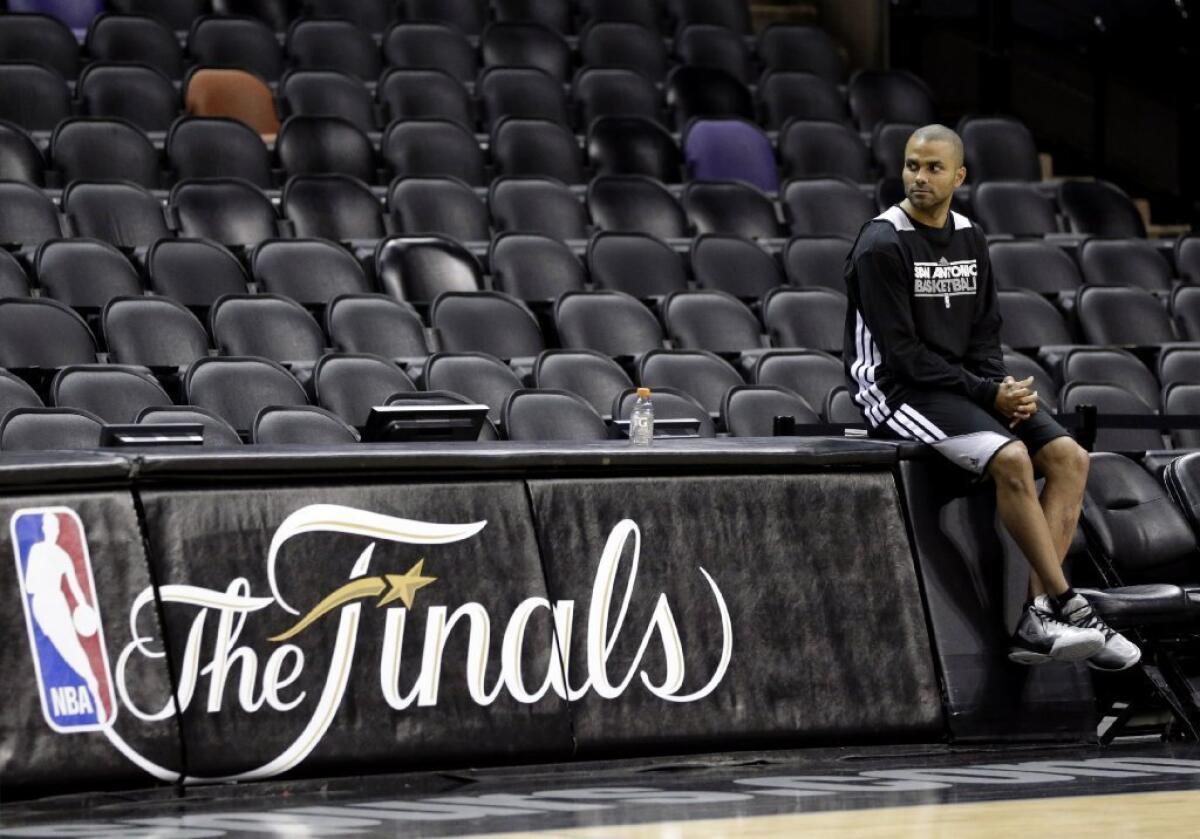 Tony Parker, who has a strained right hamstring, watches his Spurs teammates practice.