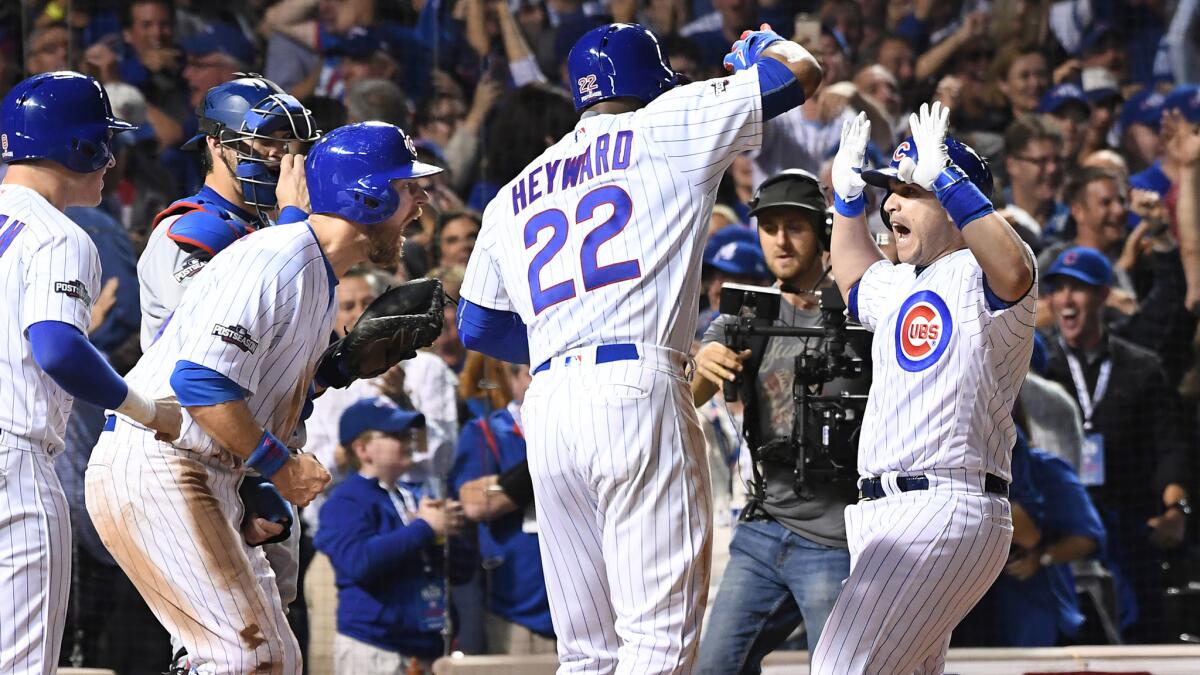 Cubs pinch-hitter Miguel Montero, right, is greeted by teammates after hitting a tiebreaking grand slam homer against the Dodgers in the eighth inning of Game 1.