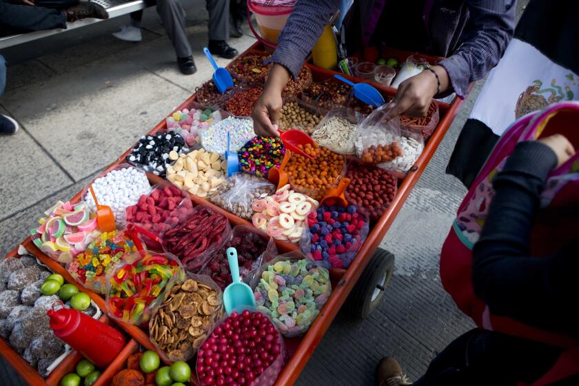 FILE - A street vendor sells sweet snacks in Mexico City, July 5, 2016. (AP Photo/Eduardo Verdugo, File)