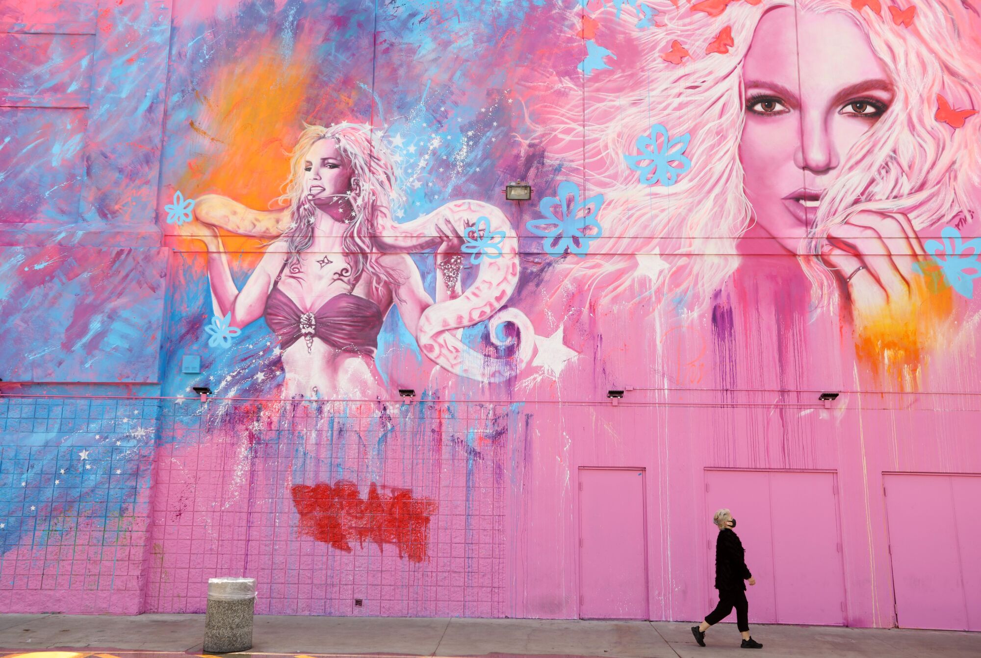 A woman walks past a building featuring Britney Spears in L.A.'s Fairfax District.