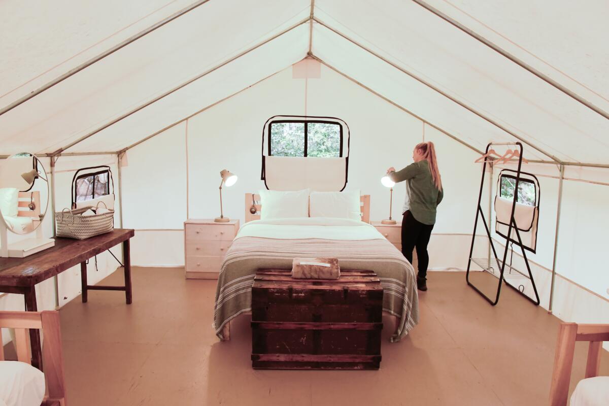 A woman standing in a large family tent at Mendocino Grove campground.