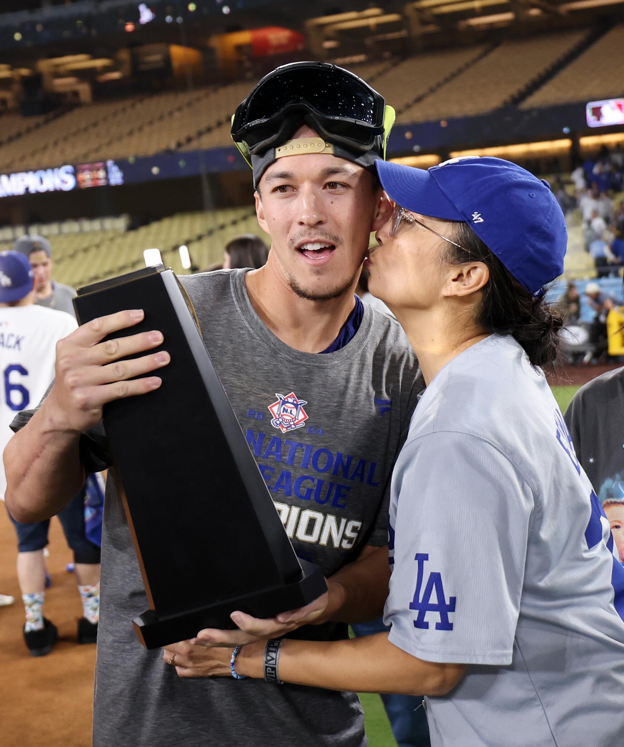 El campocorto de los Dodgers, Tommy Edman, recibe un beso de su madre en el Dodger Stadium.