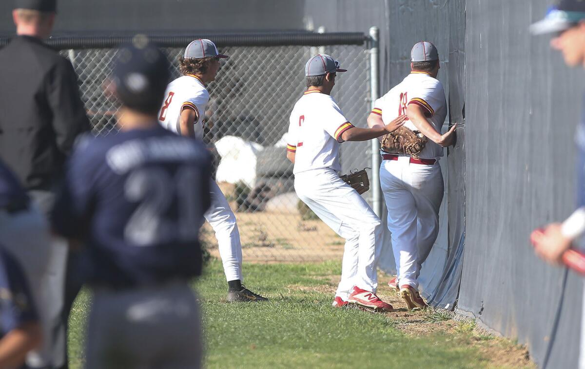 Estancia's Easton Townsend (18) holds onto the baseball after chasing down a foul ball near the fence in the third inning of an Orange Coast League opener against Calvary Chapel on Monday.
