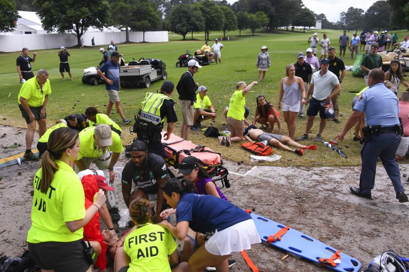 Spectators are tended to after a lightning strike on the East Lake Golf Club course left several injured during a weather delay in the third round of the Tour Championship golf tournament Saturday, Aug. 24, 2019, in Atlanta. (AP Photo/John Amis)