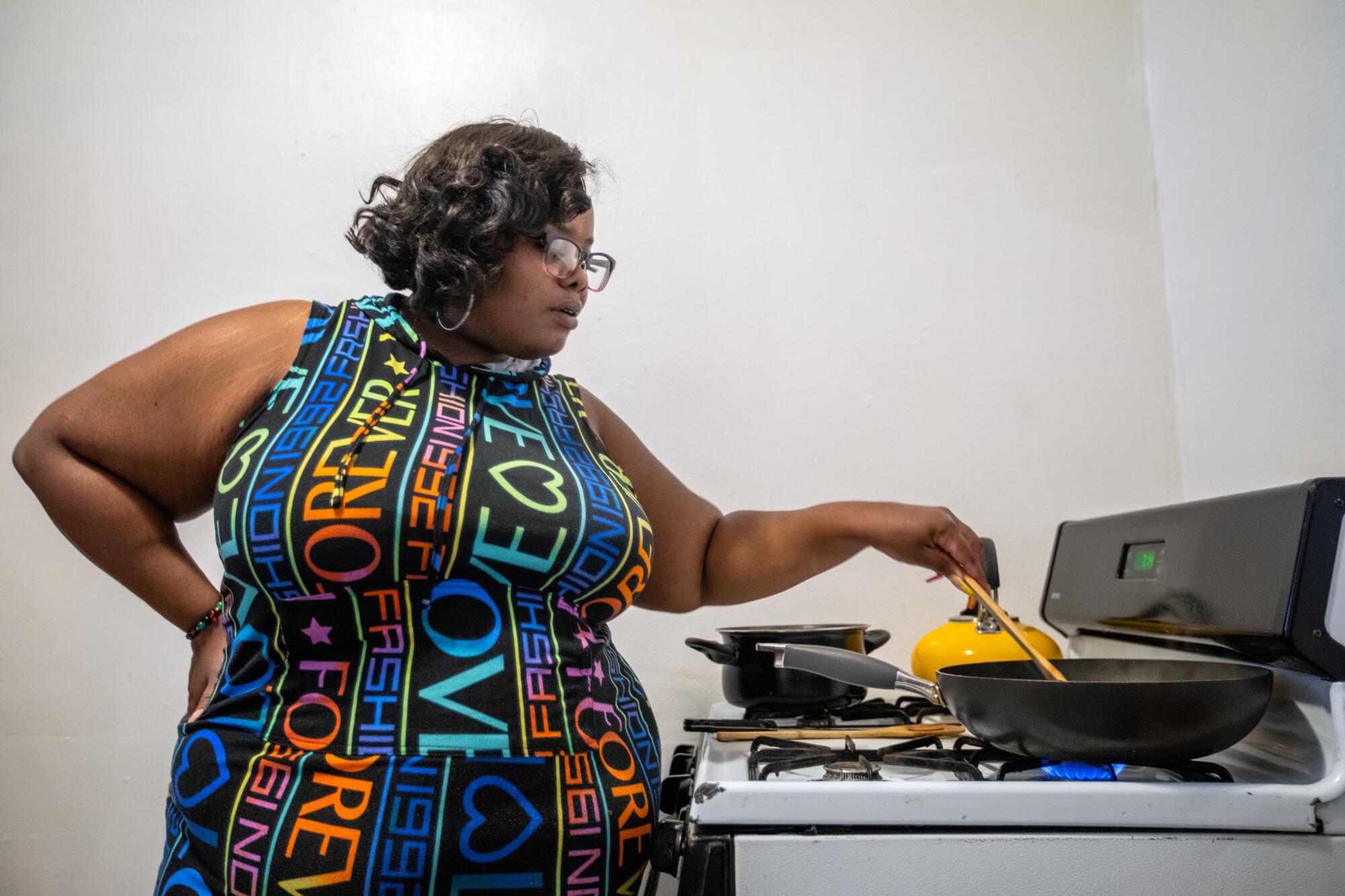 Chiniestka McFarland cooks dinner for her family in Detroit.